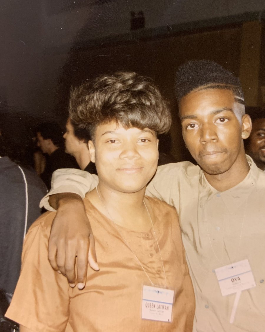 Oya Gilbert as a young hip-hop artist standing with Queen Latifah at the New Music Seminar in 1989, both wearing conference badges.